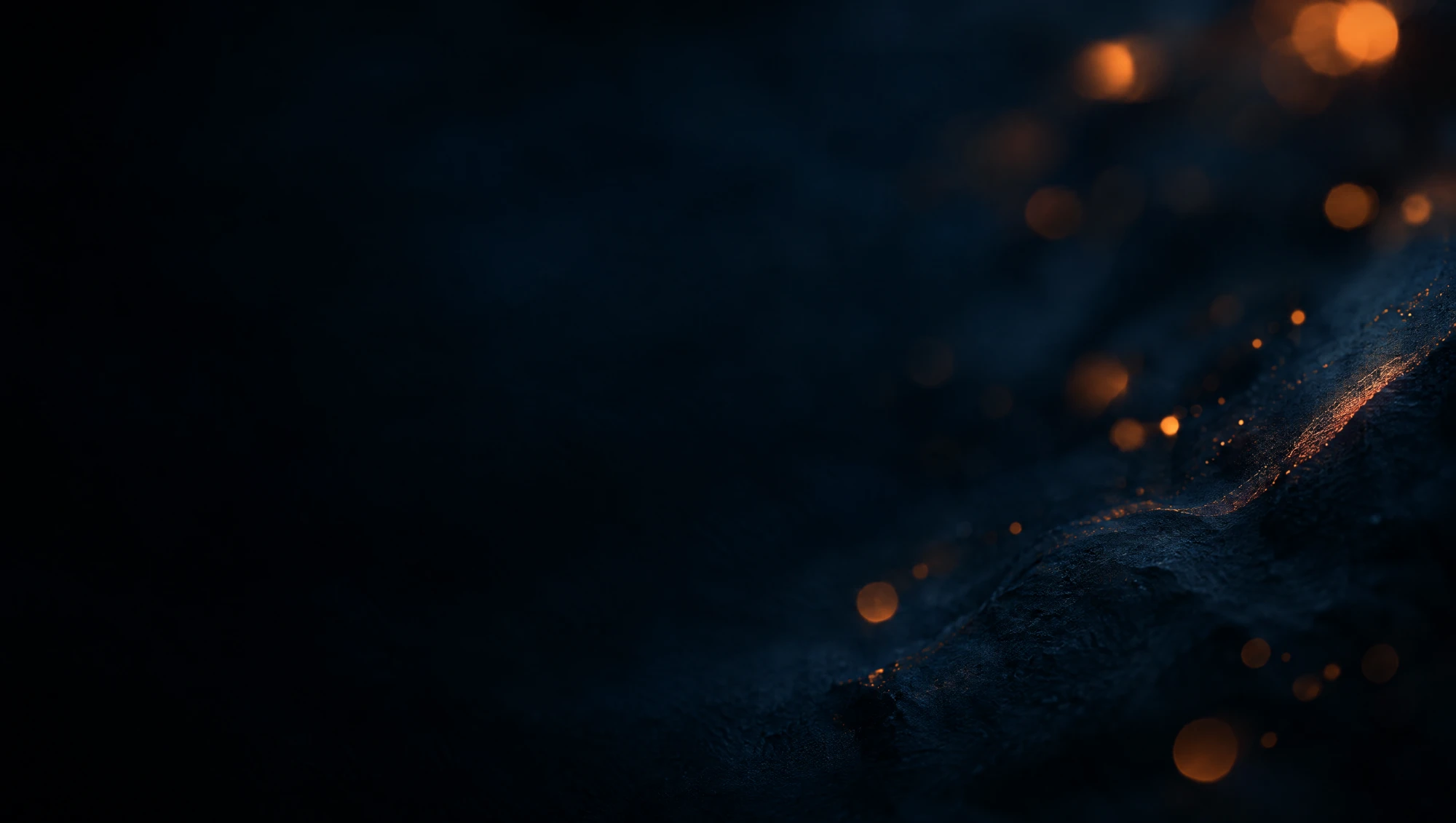 Soft out-of-focus amber light points drifting over a dark blue-black textured surface.